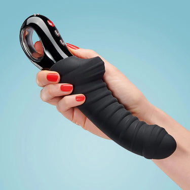 a woman's hand holding a black and red device